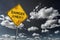 Dark blue cloudy sky and yellow faded road sign