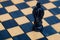 Dark blue king on wooden chessboard