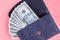 Dark blue leather wallet with money on pink background composition