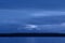Dark blue night at seaside, dramatic clouds, space for text