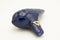 A dark blue ocarina in front of white background