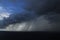 Dark blue sky with storm clouds over horizon. Thunderstorm on the ocean. Natural phenomena of nature.