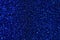 Dark blue sparkling background from small sequins, closeup. Brilliant backdrop