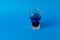 Dark blue suspicious fluid in a small crystal glass