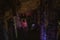 Dark blurred multicolored abstract background of stalactites, stalagmites and stalagnates in Sfendoni cave, underground,