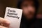 Dark blurred out of focus man in the background holding a white cards against humanity card. Adult party game popular worldwide