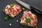 Dark bread with Italian coppa or capicola ham on a dark slate pl