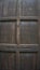 Dark brown old wooden door And usage traces With vertical shooting