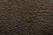 Dark brown pebbled real leather background.