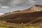 Dark brown rock ridge near Dornoch Firth, Scotland.