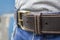 Dark brown stitched leather belt in blue jeans close-up