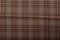 Dark brown and white checkboard pattern shirt fabric background, garment texture