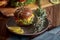 Dark burger with grain bread, salad, rosemary and lemon