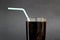 Dark carbonated drink in a glass with straws