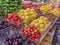 Dark cherries, cherries, apricots, strawberries and vegetables laid out on the counter of the farmers ` market