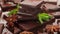 Dark chocolate bar stack and cocoa powder with mint leaf rotating, top view