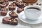 Dark chocolate biscotti cookies with almonds, covered with melted chocolate, and cup of coffee, horizontal
