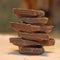 Dark chocolate. Multi-tiered tower. Close up.  White background. Chocolate construction. Small pieces of a chocolate bar. Chunks a