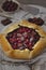 Dark chocolate and sour cherry galette crusty pie in dark and moody atmosphere