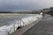 Dark clouds and breaking waves at Ballyholme Beach promenade in Bangor Northern Ireland during a winter storm in January 2017