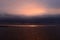 Dark cloudy sky in a thundercloud in the sunlight at sunset over the lake