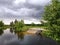 Dark cloudy storm river view. Woman on the pier