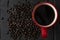 Dark coffee in red cup on wooden table