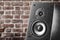 Dark color music speakers. Loud listening music. Music column on the background of a brick wall