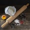 Dark composition of elements for the preparation of homemade pasta such as flour, eggs, wooden rolling pin and various accessories