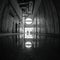 Dark corridor in an old abandoned factory. On the floor, water in which the interior is reflected