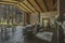 Dark cozy interior of big country wooden house, wooden furniture and animal furs. huge panoramic window and very high ceiling