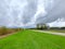 Dark cumulus clouds above green grass and wintrack power lines