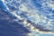 Dark Cumulus and light feathery clouds on the blue sky.