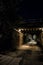 Dark and eerie city alley with vintage railway bridge at night