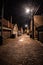 Dark and eerie urban city cobblestone brick alley at night