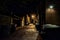 Dark and eerie urban city cobblestone brick alley at night