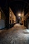 Dark and eerie urban city cobblestone brick alley at night