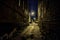 Dark and eerie urban city cobblestone brick alley at night