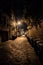 Dark and eerie urban city cobblestone brick alley at night