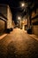 Dark and eerie urban city cobblestone brick alley at night