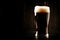 Dark english beer, ale or stout is poured into glass, dark bar c