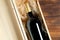 A dark expensive bottle of wine in a wooden box on a wooden background
