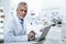 Dark-eyed caucasian pharmacist in a white coat working on a laptop