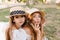 Dark-eyed girl in hat fooling around with mom enjoying family weekend in green park. Graceful woman wears elegant ring