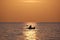 Dark figure of sportsman rowing alone on his kayak boat on sea water at sunset. Active extreme sports concept