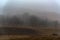 Dark foggy autumn countriside view in morning