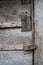 Dark gray weathered rustic rural wooden barn wall, door, gate, primitive lock timber planks closeup texture background. Empty