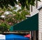 Dark green awning over store entrance on a yellow sided building.