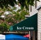 Dark green awning that says Ice Cream over store entrance on a yellow sided building.