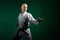 On a dark green background, an active athlete performs formal karate exercises